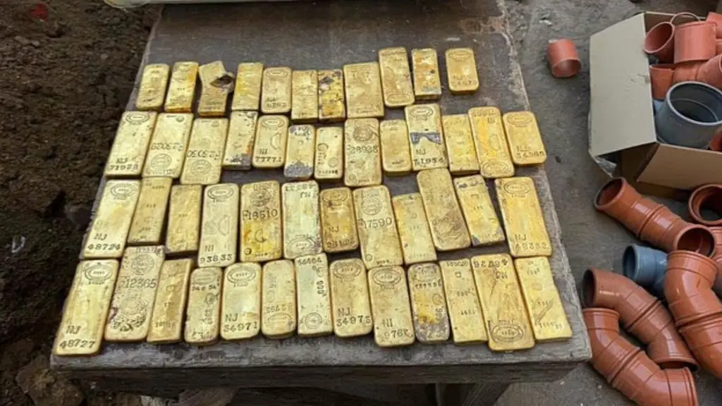 4 rows of roughly 15 gold bars laid out amongst building materials